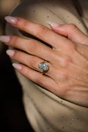 Close-up of a hand wearing a diamond ring with a blurred background