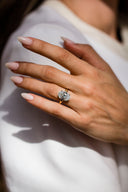 Close-up of a hand wearing a diamond ring with a blurred background